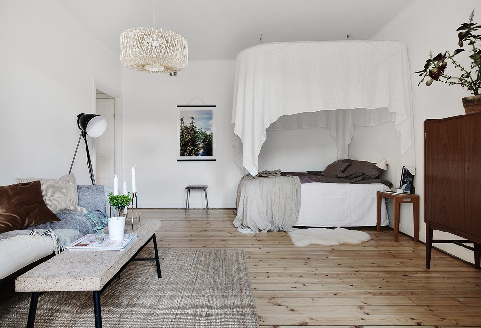 На фото: спальня в скандинавском стиле с белыми стенами, светлым паркетным полом и бежевым полом с