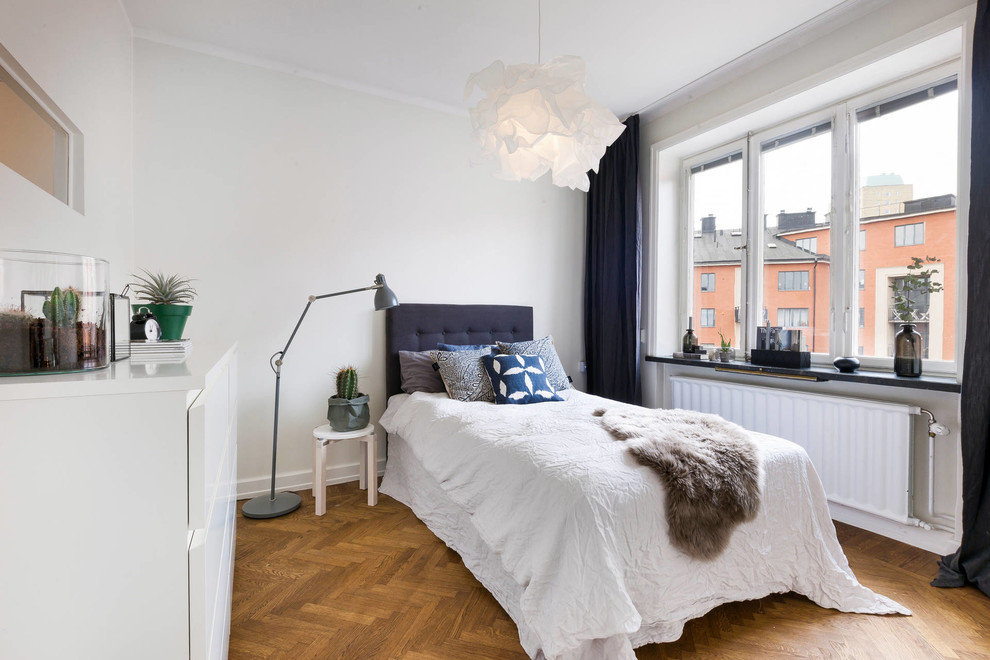 Свежая идея для дизайна: гостевая спальня (комната для гостей) в скандинавском стиле с белыми стенами и паркетным полом среднего тона - отличное фото интерьера
