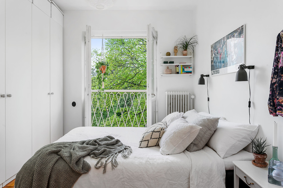 На фото: хозяйская спальня в скандинавском стиле с белыми стенами с