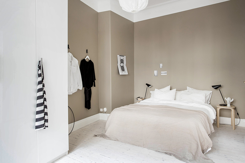 Idee per una camera da letto nordica con pareti nere e pavimento in legno massello medio