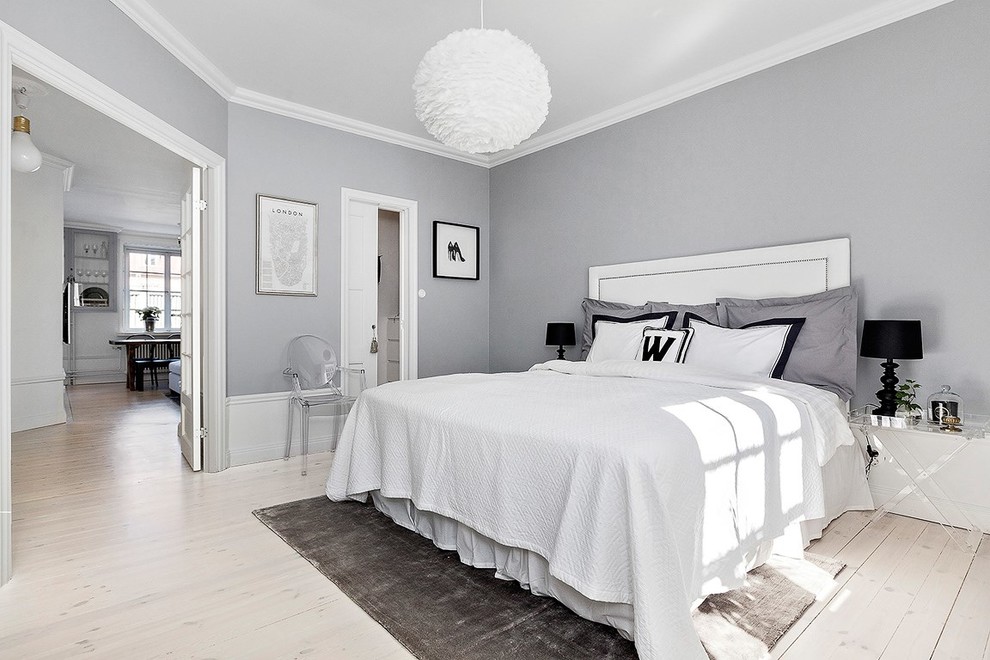 На фото: хозяйская, серо-белая спальня среднего размера в скандинавском стиле с серыми стенами и светлым паркетным полом с