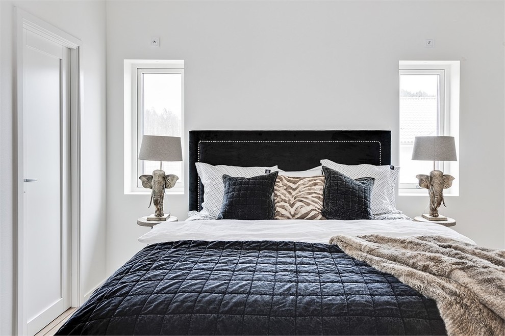 ヨーテボリにあるトランジショナルスタイルのおしゃれな客用寝室 (白い壁、淡色無垢フローリング、ベージュの床) のインテリア