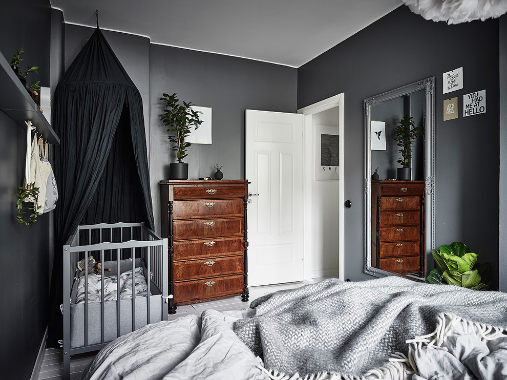 На фото: хозяйская спальня в скандинавском стиле с серыми стенами и деревянным полом с