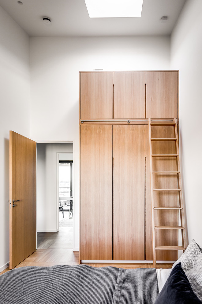 Bedroom - contemporary light wood floor and beige floor bedroom idea in Stockholm with white walls