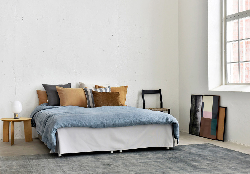 Ispirazione per una camera da letto industriale con pareti bianche, pavimento in cemento e pavimento grigio