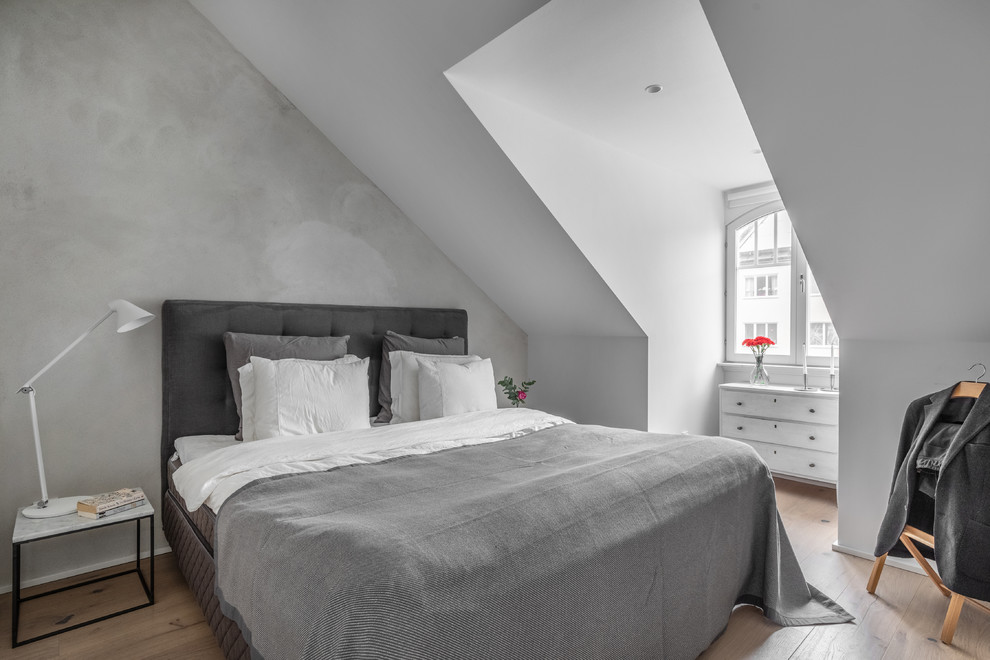 Scandi bedroom in Stockholm with grey walls and light hardwood flooring.