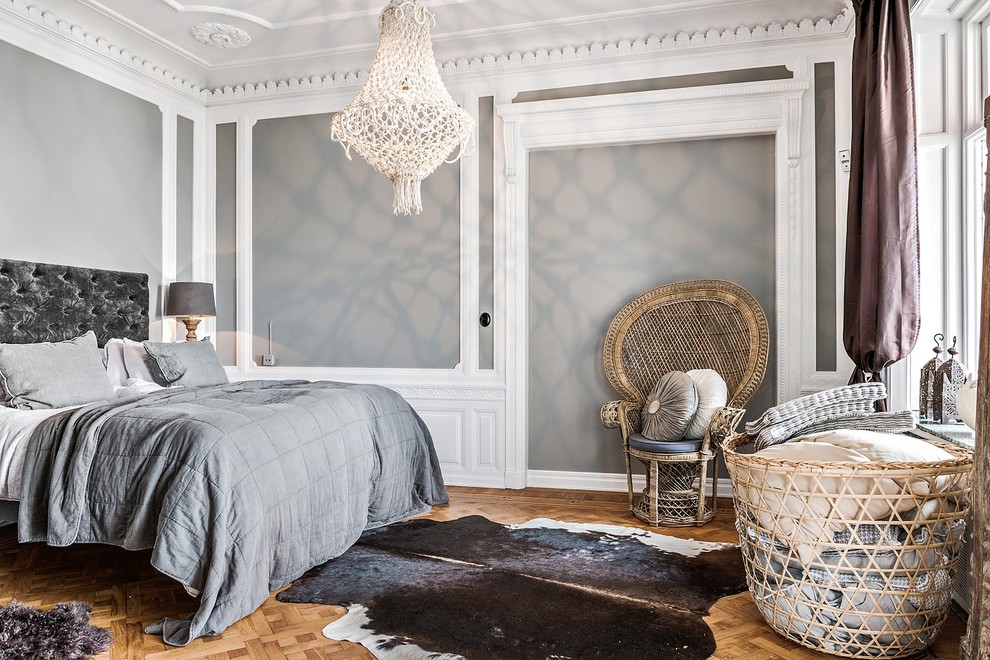 На фото: хозяйская спальня в скандинавском стиле с серыми стенами, паркетным полом среднего тона и коричневым полом