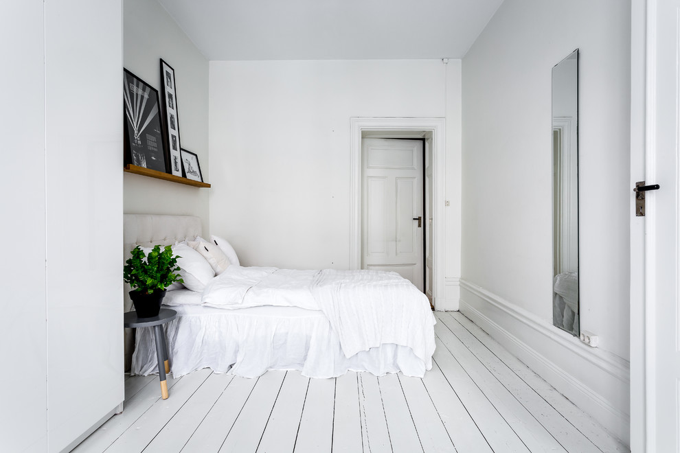 Shabby chic-inspirerad inredning av ett huvudsovrum, med vita väggar, målat trägolv och vitt golv