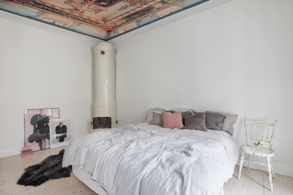Idee per una camera da letto shabby-chic style con stufa a legna, pareti bianche, parquet chiaro, cornice del camino in metallo e pavimento beige
