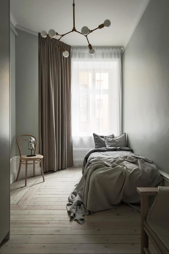 Klassisches Gästezimmer mit grauer Wandfarbe, hellem Holzboden und beigem Boden in Stockholm