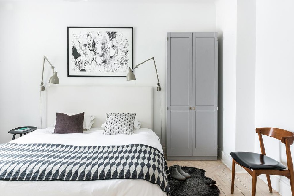 Medium sized scandi master bedroom in Gothenburg with white walls and light hardwood flooring.