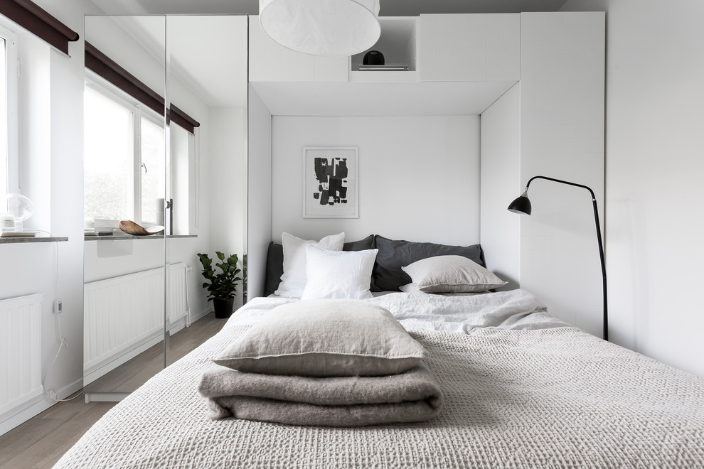 Skandinavisk inredning av ett litet sovrum, med vita väggar