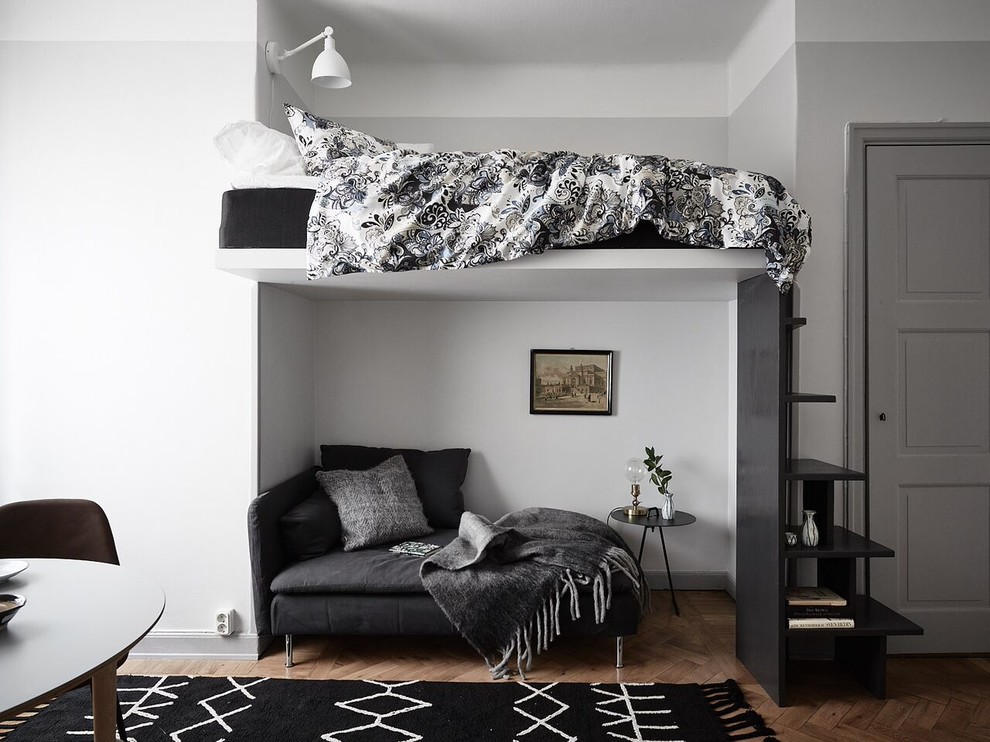 ストックホルムにある小さな北欧スタイルのおしゃれなロフト寝室 (グレーの壁、無垢フローリング、茶色い床、グレーとブラウン) のインテリア