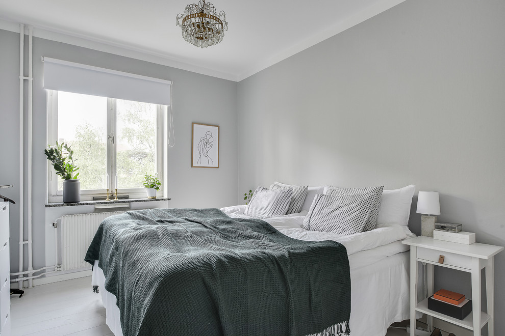 Immagine di una camera da letto scandinava di medie dimensioni con pareti grigie, pavimento in legno verniciato e pavimento bianco