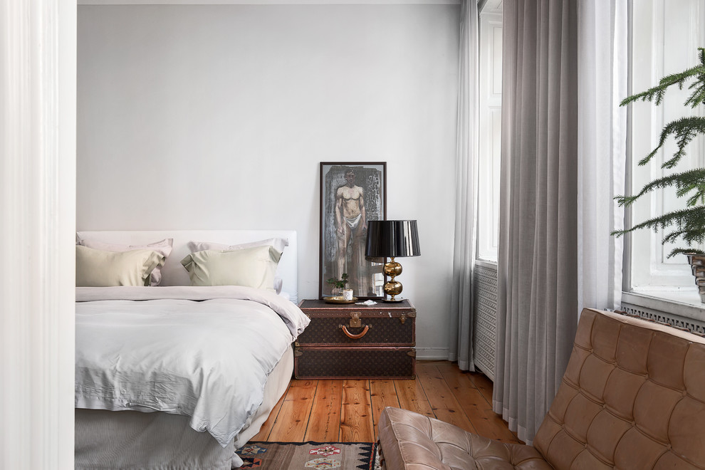 Mittelgroßes Skandinavisches Hauptschlafzimmer mit grauer Wandfarbe und braunem Holzboden in Stockholm