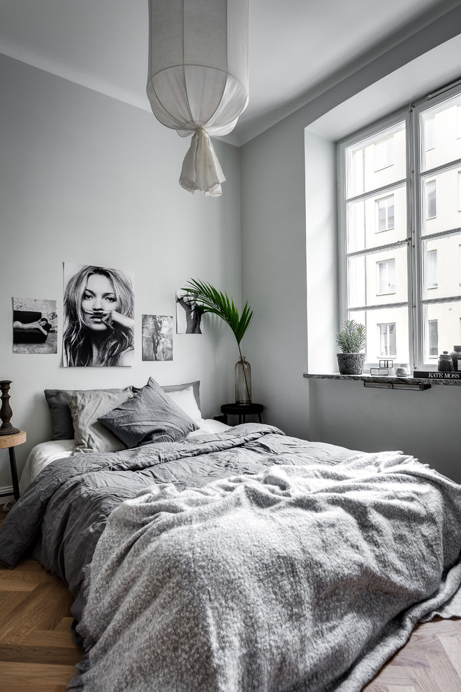 Пример оригинального дизайна: хозяйская, серо-белая спальня среднего размера в скандинавском стиле с серыми стенами и темным паркетным полом