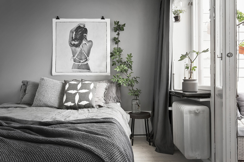 На фото: гостевая, серо-белая спальня (комната для гостей), среднего размера в скандинавском стиле с серыми стенами и светлым паркетным полом с