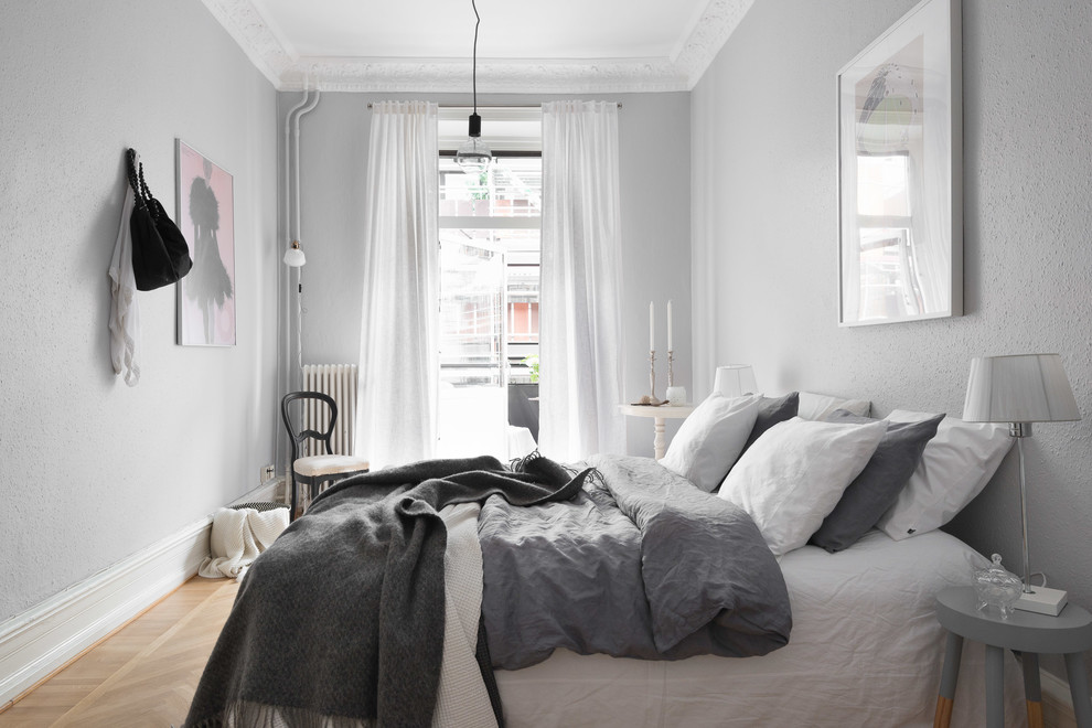 Inspiration for a medium sized traditional master bedroom in Gothenburg with grey walls, light hardwood flooring, no fireplace and brown floors.
