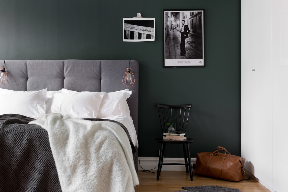 Photo of a medium sized scandi master bedroom in Gothenburg with green walls, light hardwood flooring and brown floors.