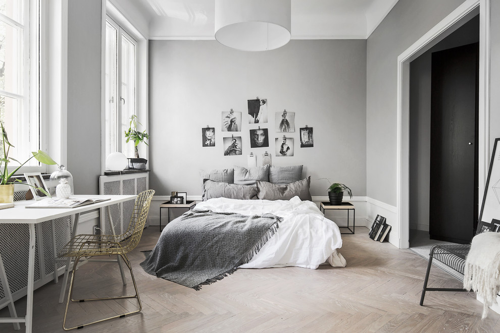 Mid-sized danish master light wood floor bedroom photo in Stockholm with gray walls
