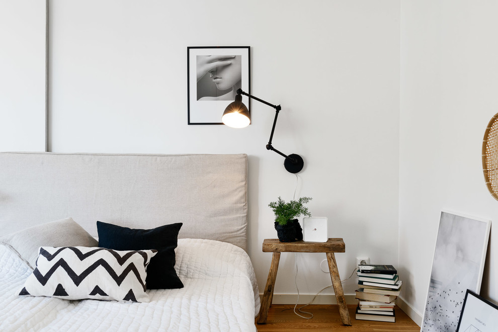 Inspiration för ett mellanstort minimalistiskt huvudsovrum, med vita väggar och mellanmörkt trägolv