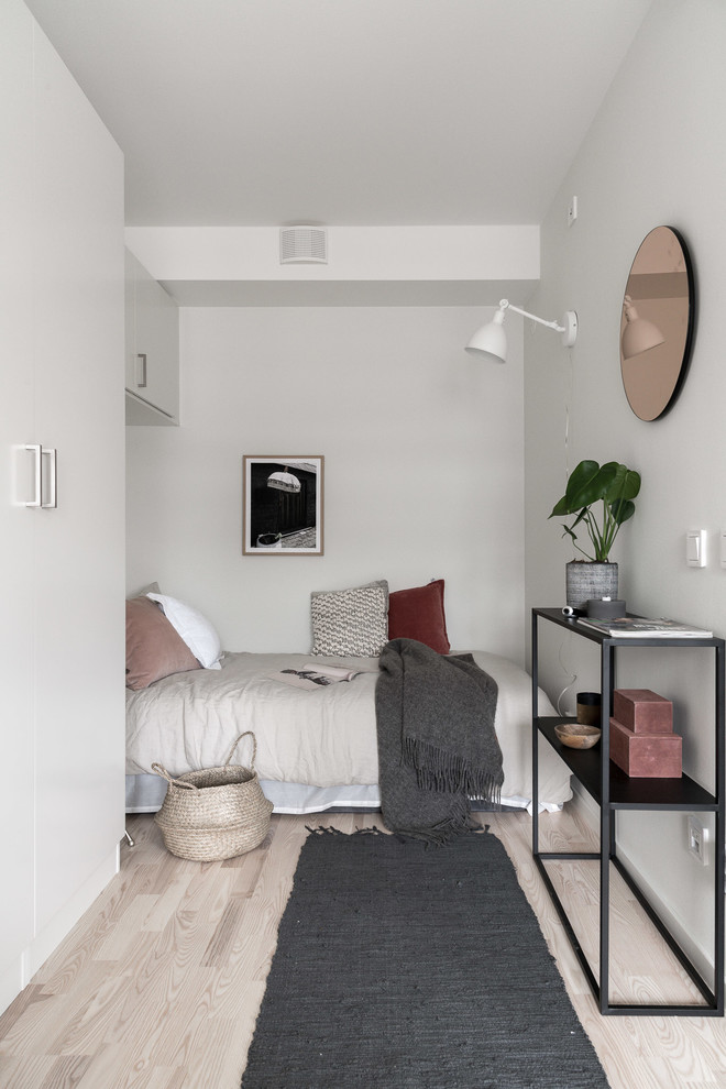 Aménagement d'une petite chambre parentale scandinave avec un mur blanc, parquet clair et un sol beige.