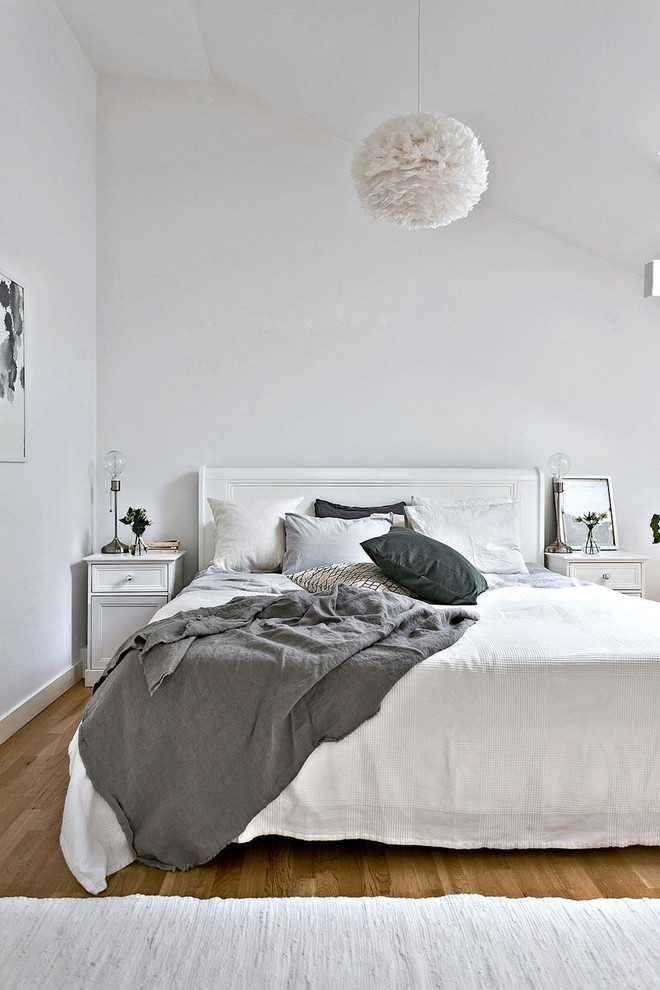 Mittelgroßes Nordisches Hauptschlafzimmer mit weißer Wandfarbe und hellem Holzboden in Stockholm