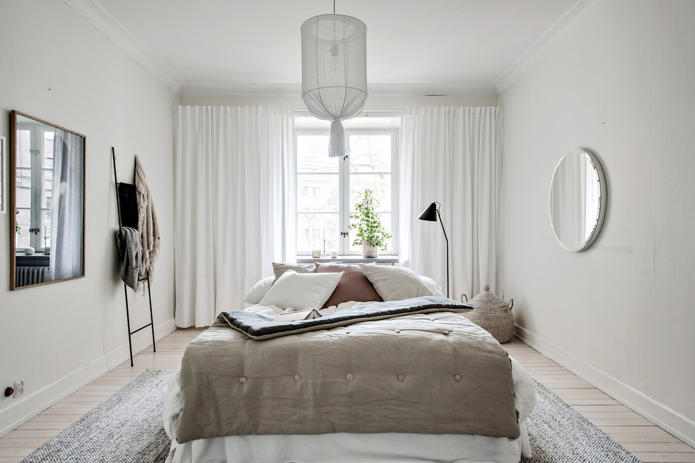 Ejemplo de dormitorio nórdico con paredes blancas, suelo de madera clara y suelo beige