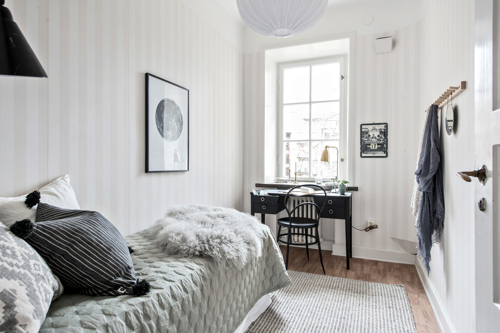 This is an example of a scandinavian bedroom in Gothenburg with beige walls, medium hardwood flooring and brown floors.