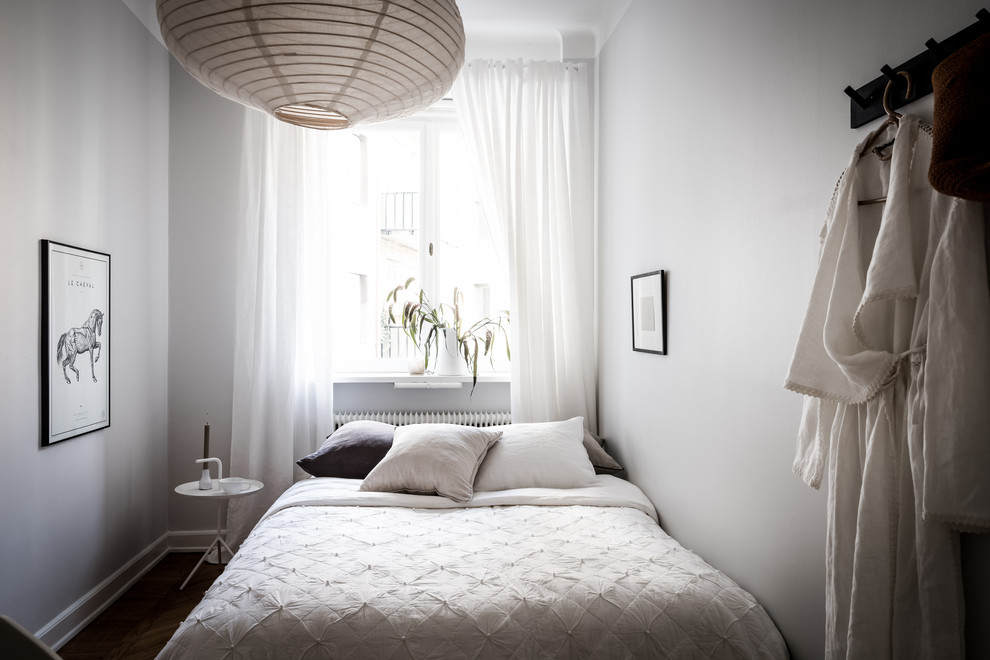 Kleines Skandinavisches Schlafzimmer mit weißer Wandfarbe und braunem Boden in Göteborg