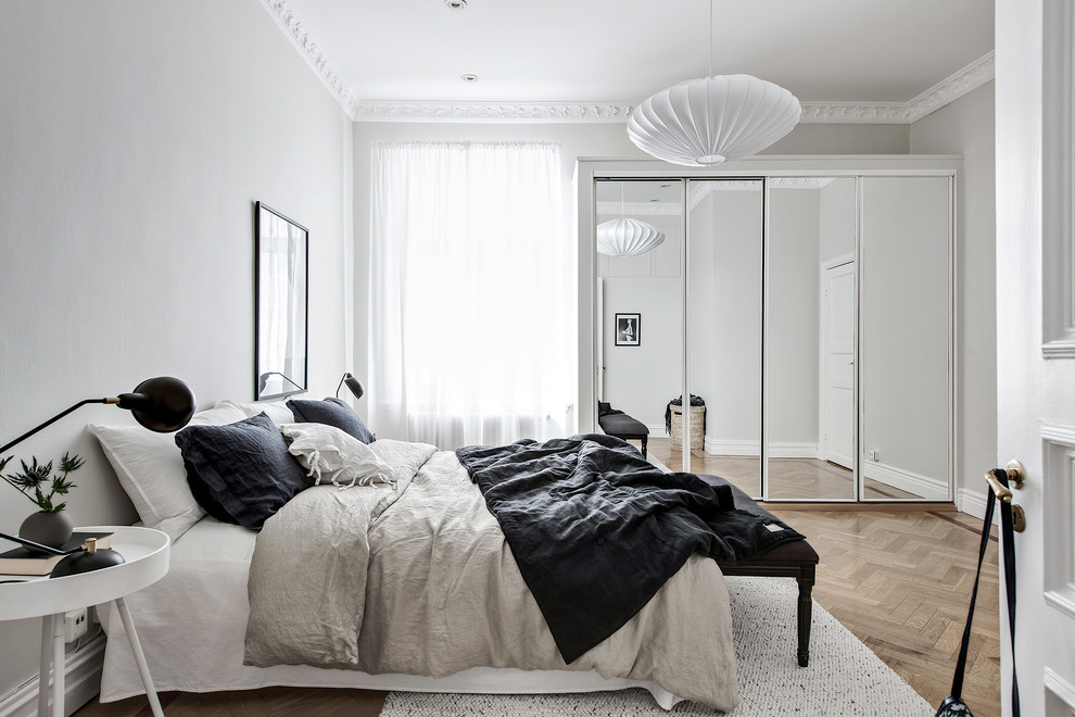Idée de décoration pour une chambre parentale grise et noire nordique avec un mur gris, parquet clair et un sol beige.