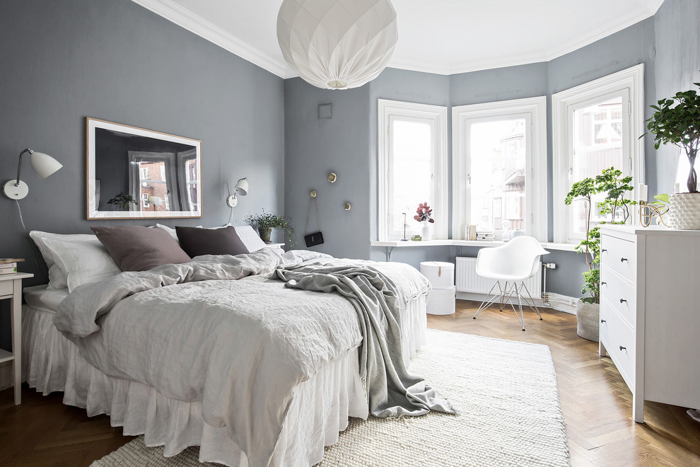 ヨーテボリにある北欧スタイルのおしゃれな主寝室 (グレーの壁、無垢フローリング、暖炉なし、茶色い床) のレイアウト