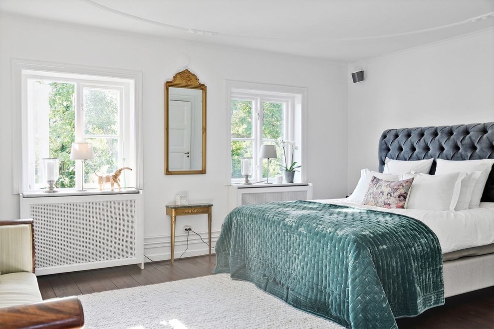 Imagen de dormitorio principal clásico con paredes blancas, suelo de madera oscura y suelo marrón
