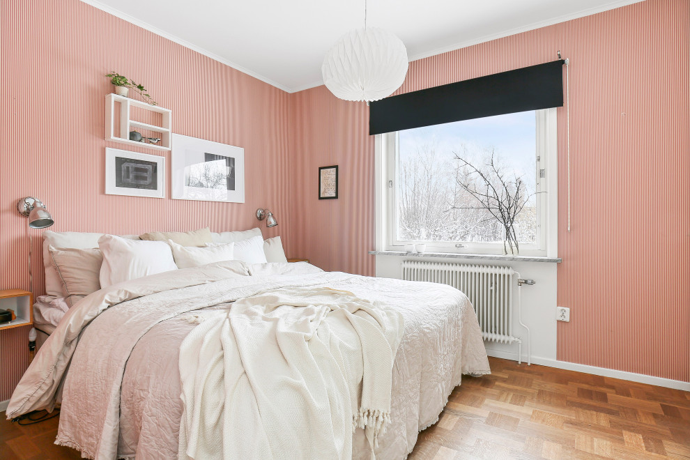 Réalisation d'une chambre grise et rose nordique de taille moyenne avec un mur rouge, un sol en bois brun, aucune cheminée et un sol marron.