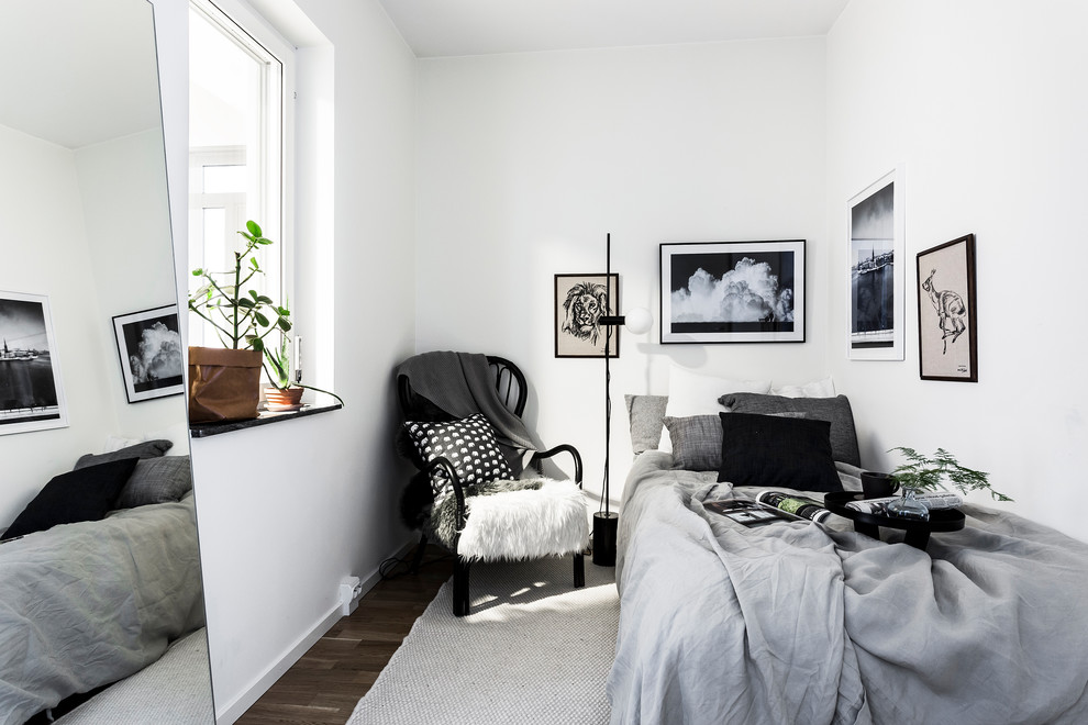 Design ideas for a scandinavian guest bedroom in Stockholm with white walls and dark hardwood flooring.
