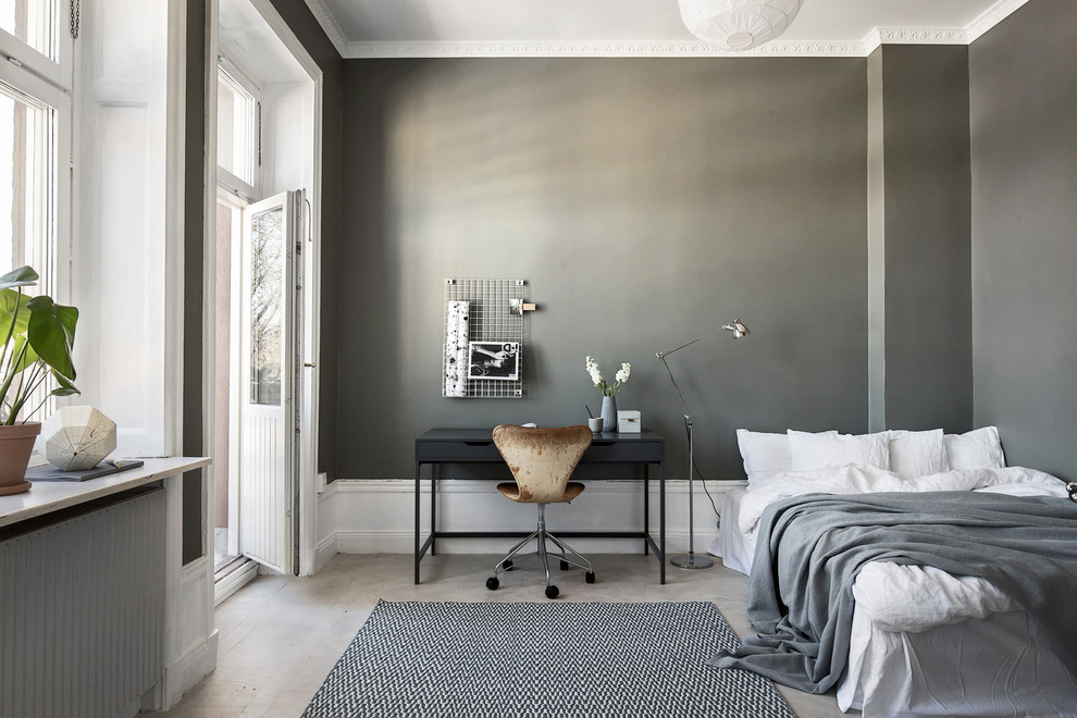 Diseño de dormitorio principal urbano sin chimenea con paredes grises, suelo de madera clara, suelo gris y con escritorio