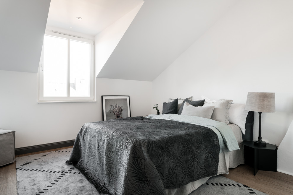 Mittelgroßes Nordisches Hauptschlafzimmer mit weißer Wandfarbe, braunem Holzboden und braunem Boden in Stockholm