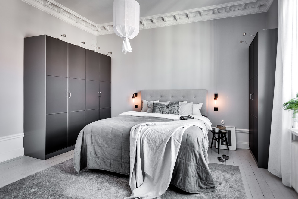 ストックホルムにある中くらいな北欧スタイルのおしゃれな主寝室 (グレーの壁、塗装フローリング)