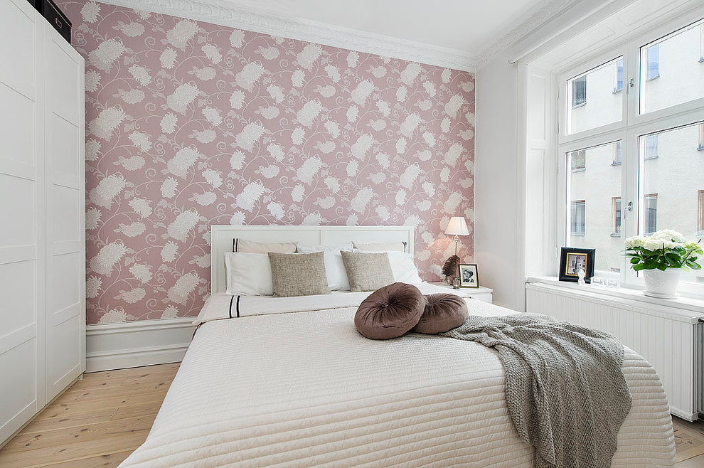 Mittelgroßes Skandinavisches Hauptschlafzimmer ohne Kamin mit rosa Wandfarbe und hellem Holzboden in Stockholm