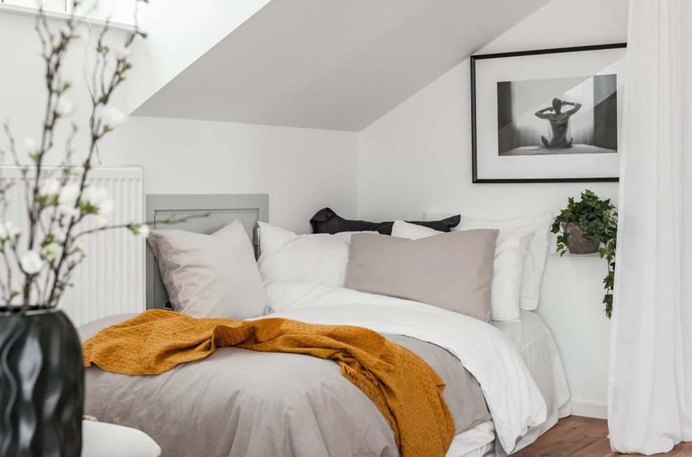 На фото: маленькая хозяйская спальня в скандинавском стиле с белыми стенами, коричневым полом и паркетным полом среднего тона для на участке и в саду