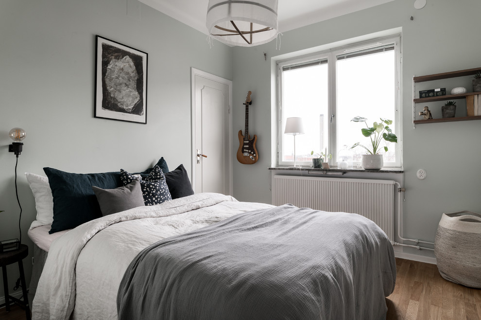Inspiration for a scandinavian medium tone wood floor and beige floor bedroom remodel in Stockholm with gray walls