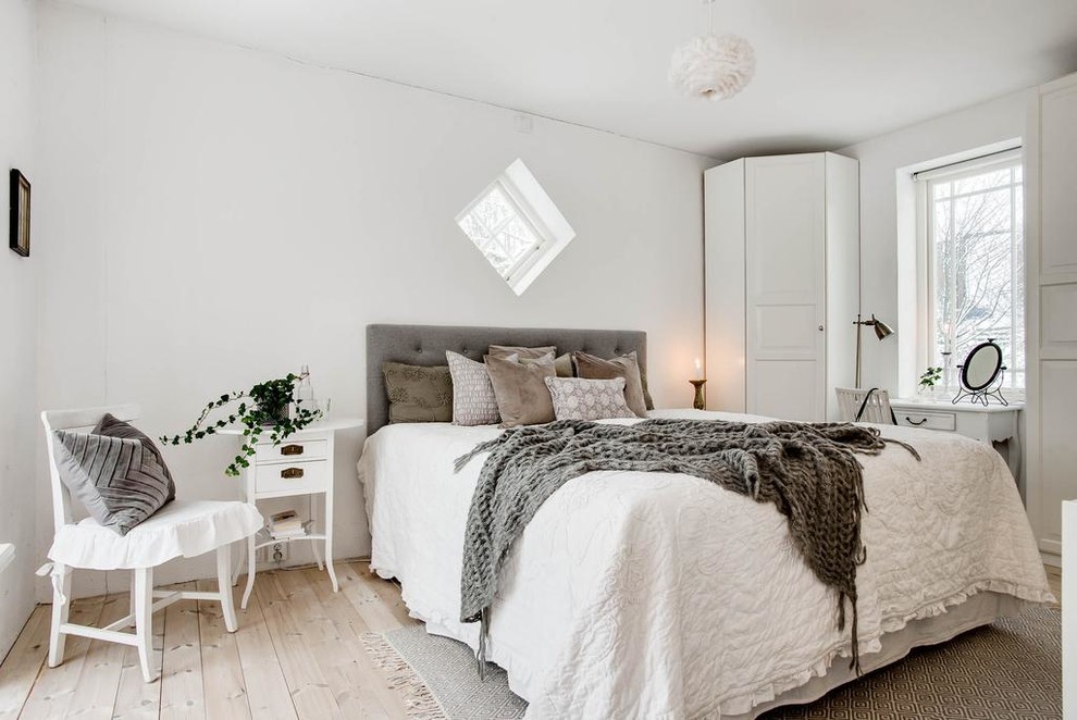 Mittelgroßes Nordisches Schlafzimmer ohne Kamin mit weißer Wandfarbe, hellem Holzboden und beigem Boden in Stockholm