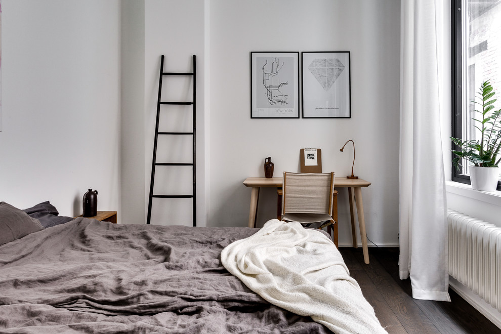 На фото: хозяйская спальня среднего размера в скандинавском стиле с белыми стенами и темным паркетным полом