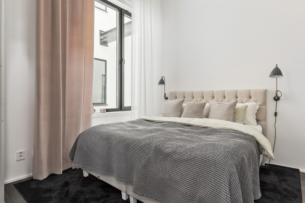 Imagen de dormitorio principal escandinavo grande sin chimenea con paredes blancas y suelo de madera oscura