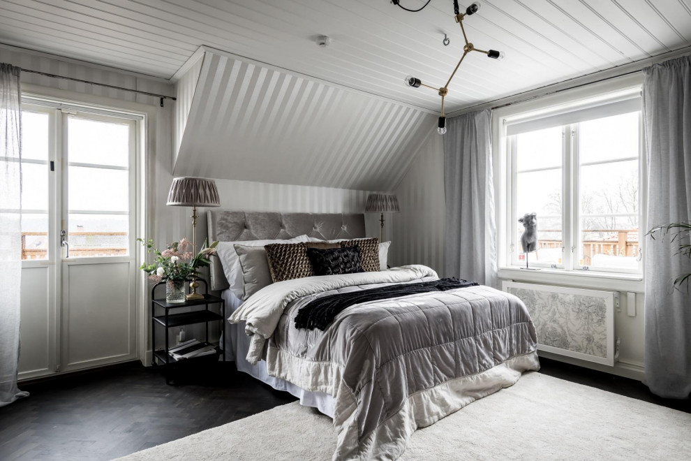 Inredning av ett nordiskt sovrum, med grå väggar, mörkt trägolv och brunt golv