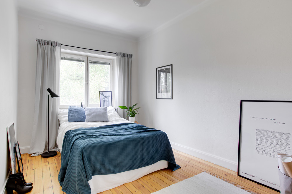 Diseño de habitación de invitados nórdica con paredes blancas, suelo de madera clara y suelo beige