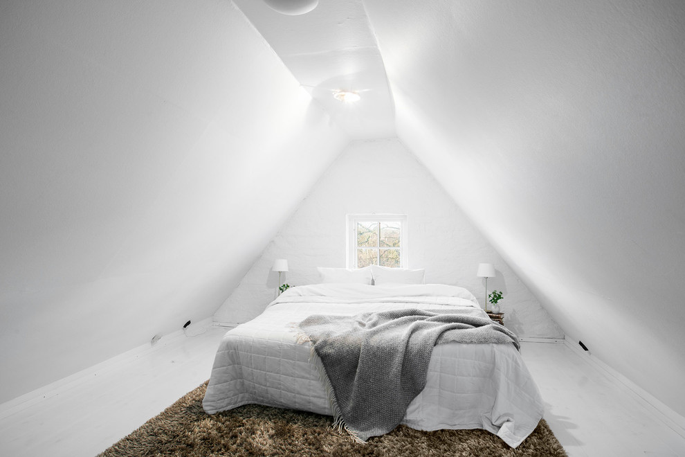 Modelo de dormitorio principal escandinavo grande con paredes blancas, suelo de madera pintada y techo inclinado
