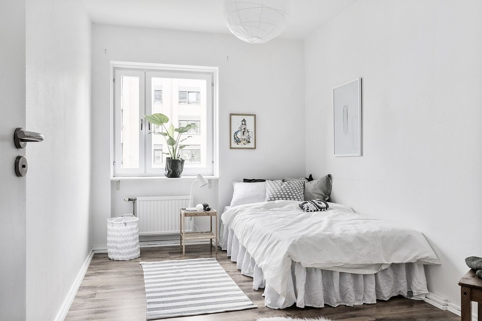 Идея дизайна: спальня в скандинавском стиле с белыми стенами, темным паркетным полом и коричневым полом