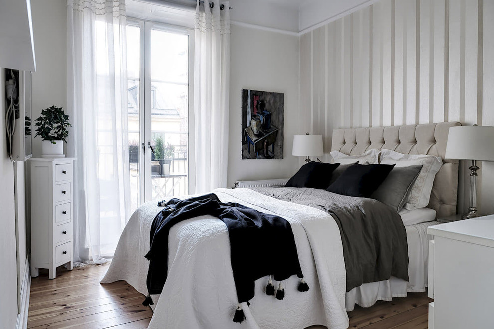 Photo of a scandi bedroom in Stockholm with multi-coloured walls, light hardwood flooring and no fireplace.