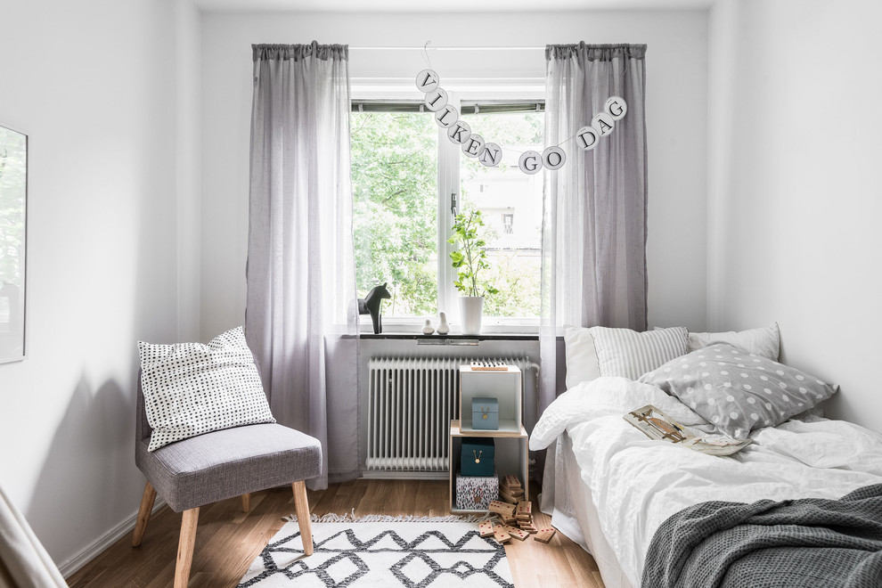 ヨーテボリにある中くらいな北欧スタイルのおしゃれな客用寝室 (白い壁、無垢フローリング)
